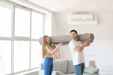 Yeni dairede halısı olan genç çift.