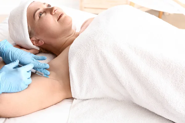 Женщина, получающая инъекцию ботокса в подмышку для лечения гипергидроза в салоне красоты — стоковое фото