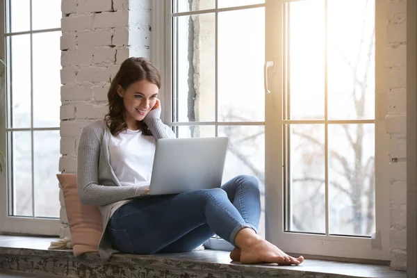 Bella giovane donna con computer portatile a riposo a casa — Foto Stock
