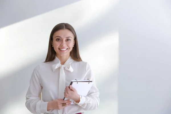 Elegante donna d'affari con notebook su sfondo chiaro — Foto Stock