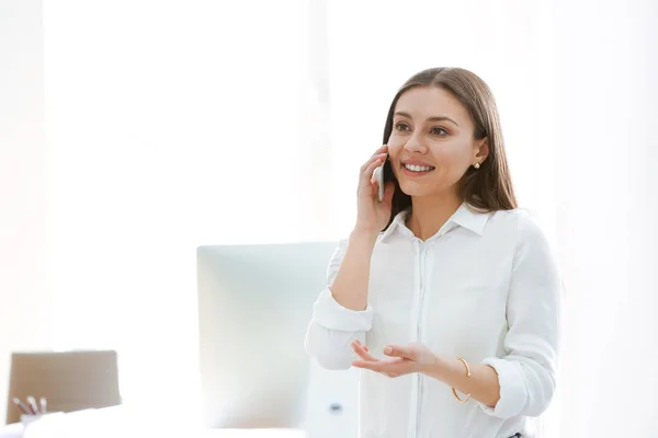 Kobieta rozmawia przez telefon komórkowy w biurze — Zdjęcie stockowe