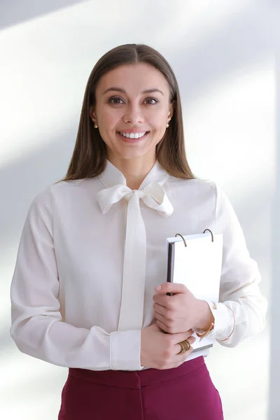 Стильна бізнес-леді з блокнотом на світлому фоні — стокове фото