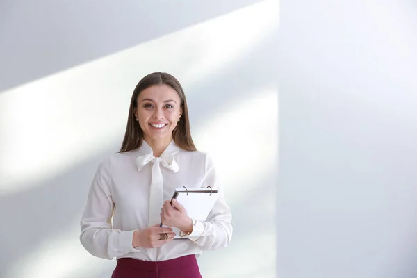 Elegante donna d'affari con notebook su sfondo chiaro — Foto Stock