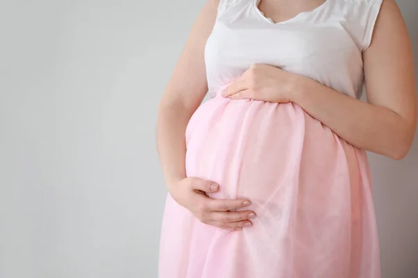 Bella donna incinta su sfondo chiaro — Foto Stock