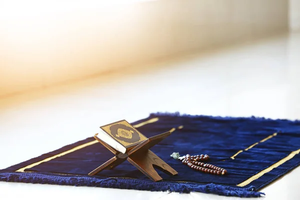 Corán y tasbih sobre la alfombra de oración musulmana — Foto de Stock