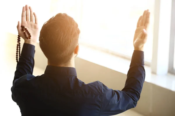 Young Muslim man praying indoors — Stock Photo, Image