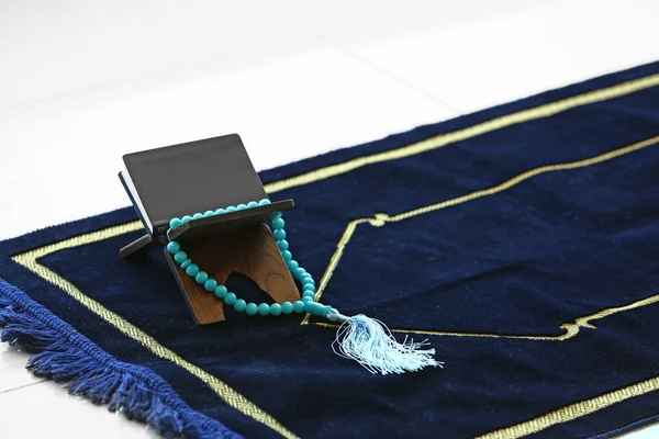 Koran and tasbih on Muslim prayer mat — Stock Photo, Image