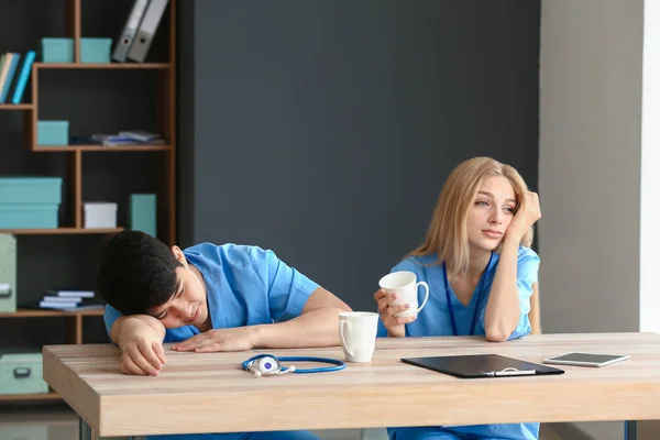 Assistants médicaux fatigués à table à la clinique — Photo