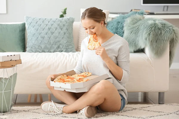 Beautiful woman eating tasty pizza at home — Stock Photo, Image