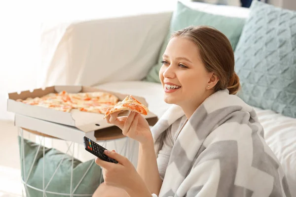 Красива жінка їсть смачну піцу і дивиться телевізор вдома — стокове фото