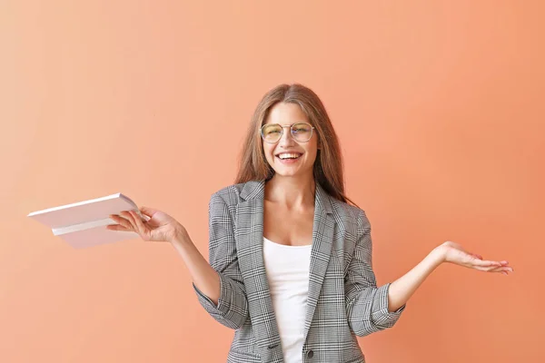 Beautiful young woman with book on color background — Stock Photo, Image