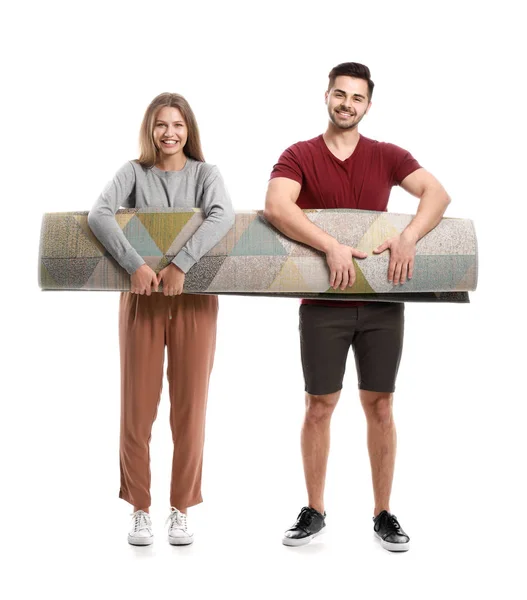 Young couple with rolled carpet against white background — Stock Photo, Image