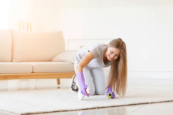 Mujer joven limpieza de alfombras en casa — Foto de Stock