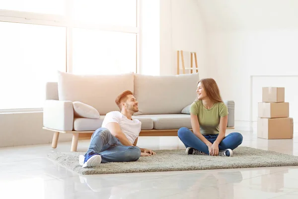 Young couple resting on soft carpet at home — Stock Photo, Image