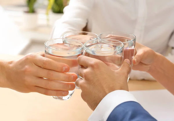 People drinking water in office, closeup