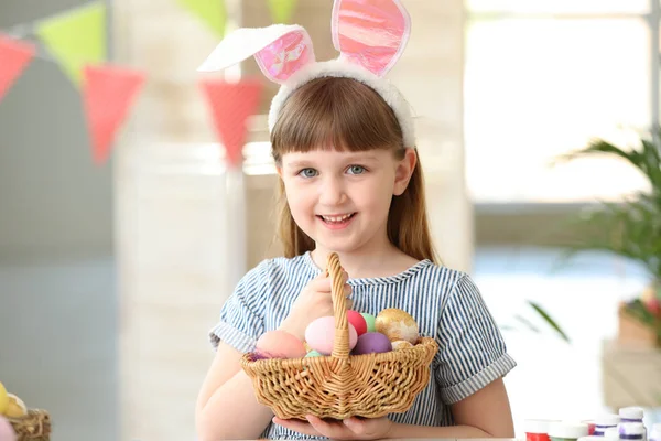 Sepet evde boyalı Paskalya yumurtaları dolu küçük kız — Stok fotoğraf