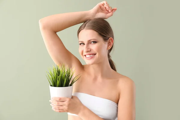 Hermosa mujer joven con planta sobre fondo de color. Concepto de depilación — Foto de Stock