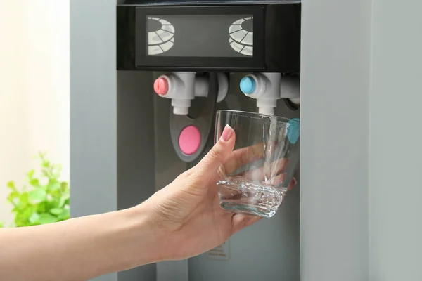 Woman pouring water from cooler into glass, closeup — Stock Photo, Image