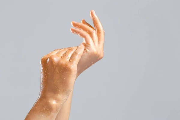 Beautiful young woman applying body scrub against grey background — Stock Photo, Image