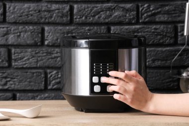 Kadın masadaki modern çoklu ocağı açıyor.