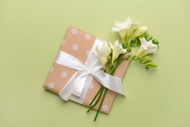 Güzel freesia çiçek ve hediye renk arka plan üzerinde