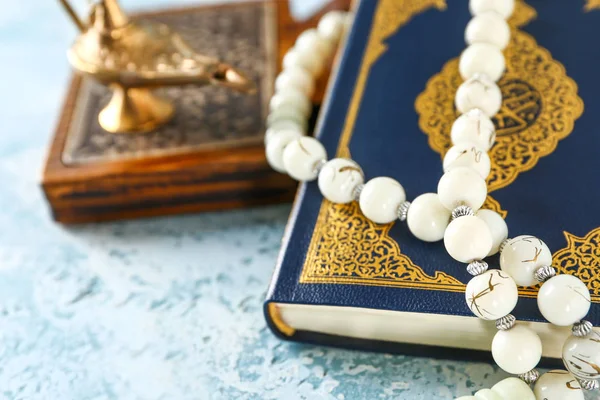 Muslim beads and Koran on color background, closeup — Stock Photo, Image