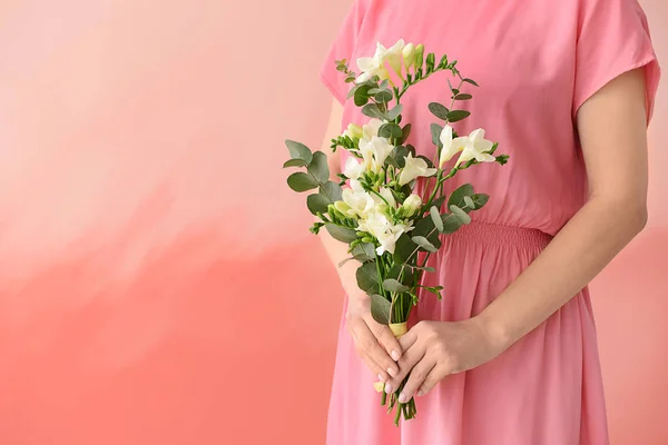 Woman with beautiful freesia flowers on color background — Stock Photo, Image