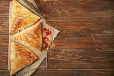 Ahşap masada soslu lezzetli samosas