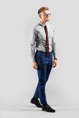 Going young businessman on grey background