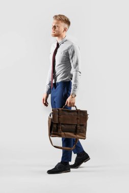 Going young businessman on grey background