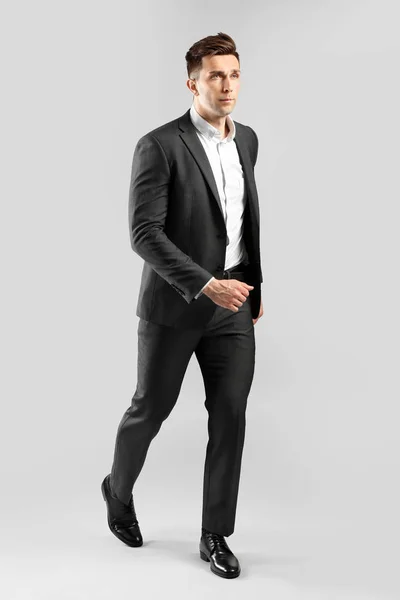 Going young businessman on grey background — Φωτογραφία Αρχείου