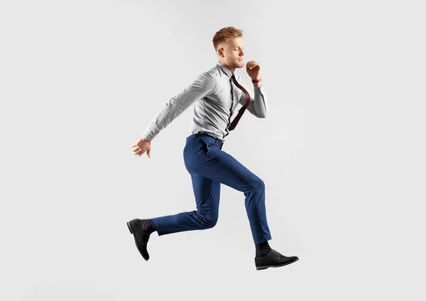 Correr joven empresario sobre fondo gris — Foto de Stock