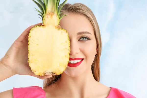 Beautiful young woman with half of pineapple on color background — Stock Photo, Image