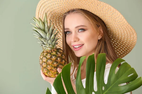 Hermosa mujer joven con piña y hoja tropical sobre fondo de color —  Fotos de Stock