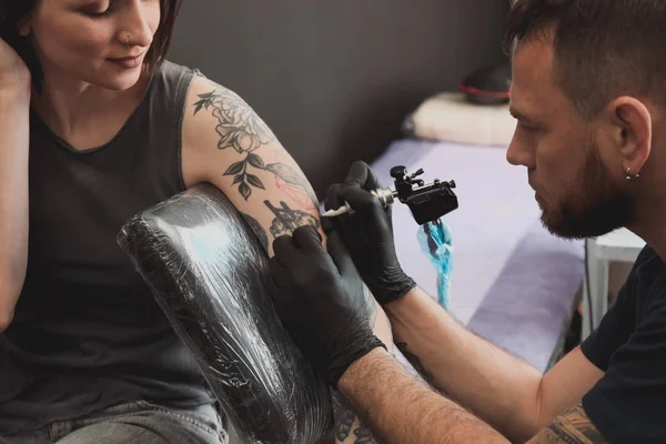 Professional artist making tattoo in salon — Stock Photo, Image