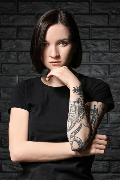 Vacker tatuerad kvinna på mörk bakgrund — Stockfoto