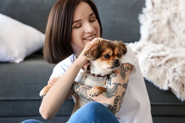Beautiful tattooed woman with cute dog at home — Stock Photo, Image