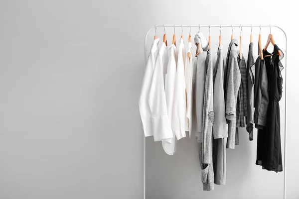 Rack with stylish clothes on light background — Stock Photo, Image