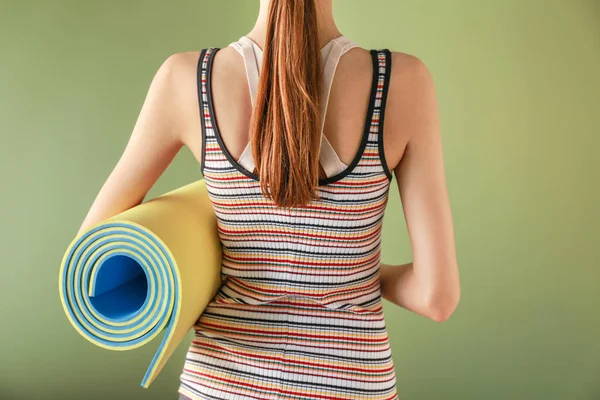 Young sporty woman with yoga mat on color background — Stock Photo, Image