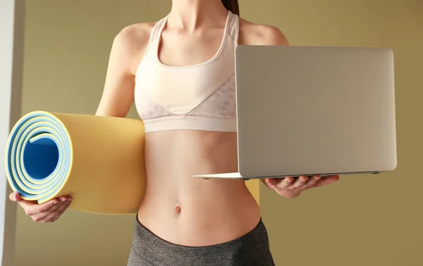 Young sporty woman with yoga mat and laptop. Concept of balance between rest and work — 스톡 사진