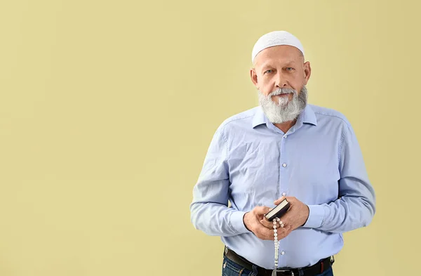 Senior muzulmán ember, Koran és tasbih ellen színes háttér — Stock Fotó