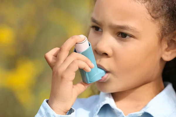 African-American girl with inhaler having asthma attack outdoors on spring day — Stock Photo, Image