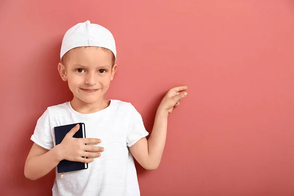 Kis muszlim fiú Koran mutatott valamit a színes háttér — Stock Fotó