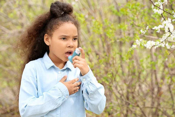 African-American girl with inhaler having asthma attack outdoors on spring day — Stock Photo, Image