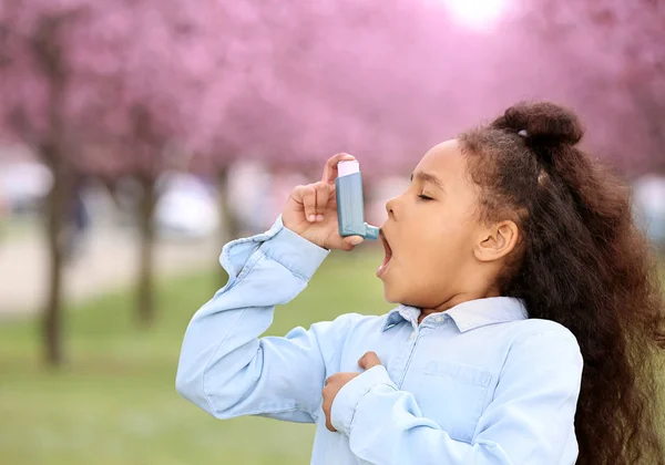 Chica afroamericana con inhalador que sufre un ataque de asma al aire libre en el día de primavera —  Fotos de Stock