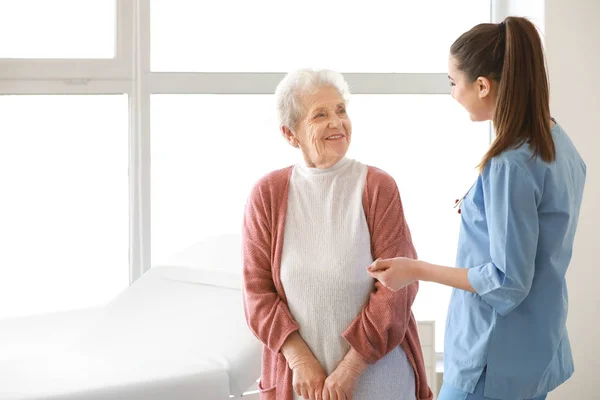Medical worker with senior woman in nursing home