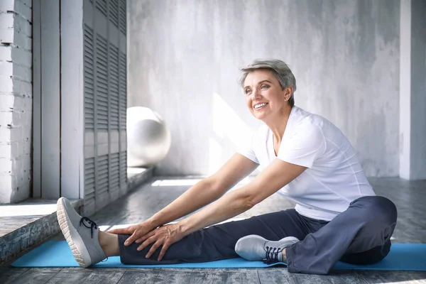 Esportivo mulher madura formação em casa — Fotografia de Stock