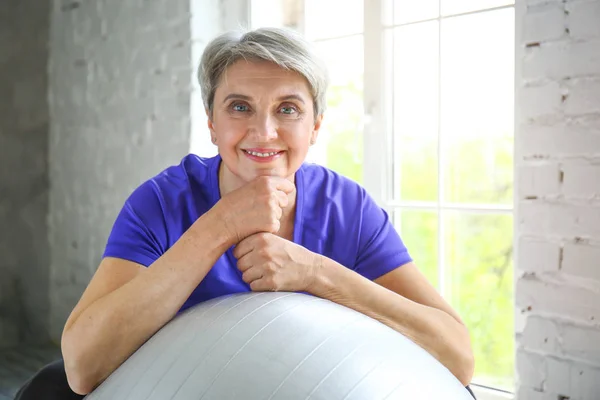 Sportieve rijpe vrouw met fitball thuis — Stockfoto