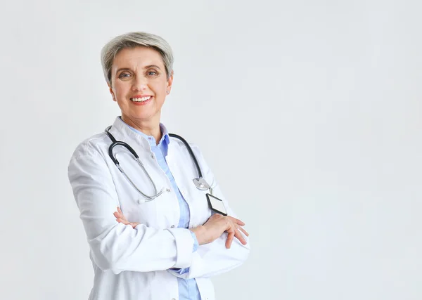 Mature female doctor on light background — Stock Photo, Image