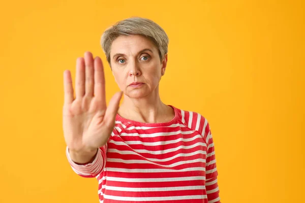Портрет зрілої жінки, що показує жест STOP на кольоровому фоні — стокове фото